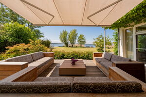 Ferienhaus Peeneblick - private Terrasse mit Blick auf das Grundstück am Wasser