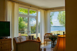 Ferienhaus Peeneblick - Panoramafenster mit Blick auf das Grundstück am Wasser