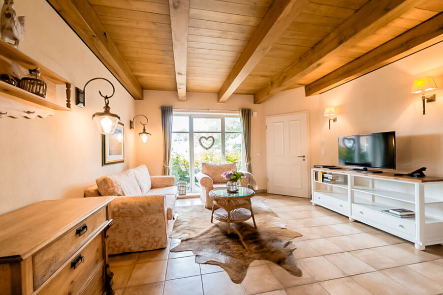 Geräumiges Wohnzimmer mit Holzbalkendecke und Terrassenzugang