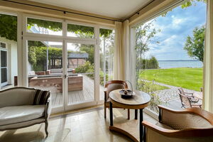 Ferienhaus Peeneblick - Panoramafenster mit Blick auf das Grundstück am Wasser